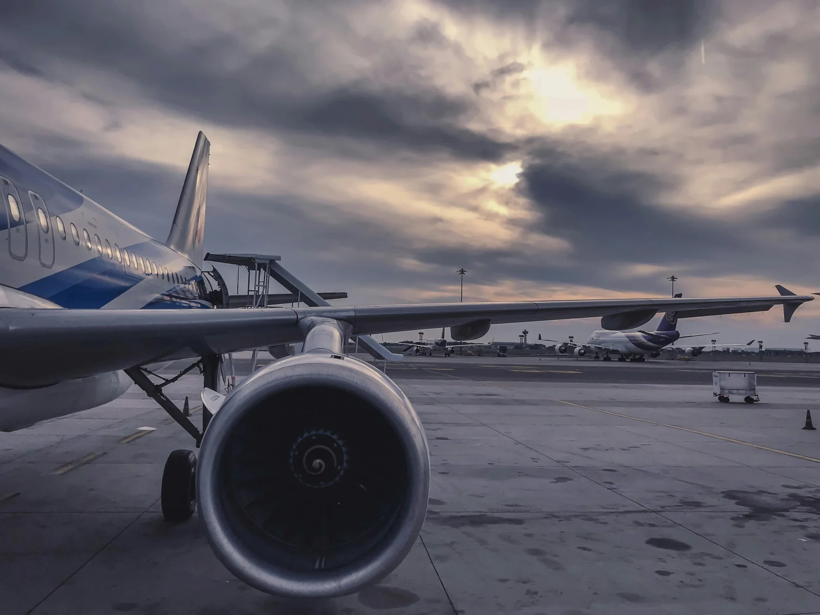 Airplanes on a tarmac under a dramatic sky